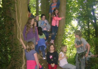 Young children having fun in the woods during Holiday Club